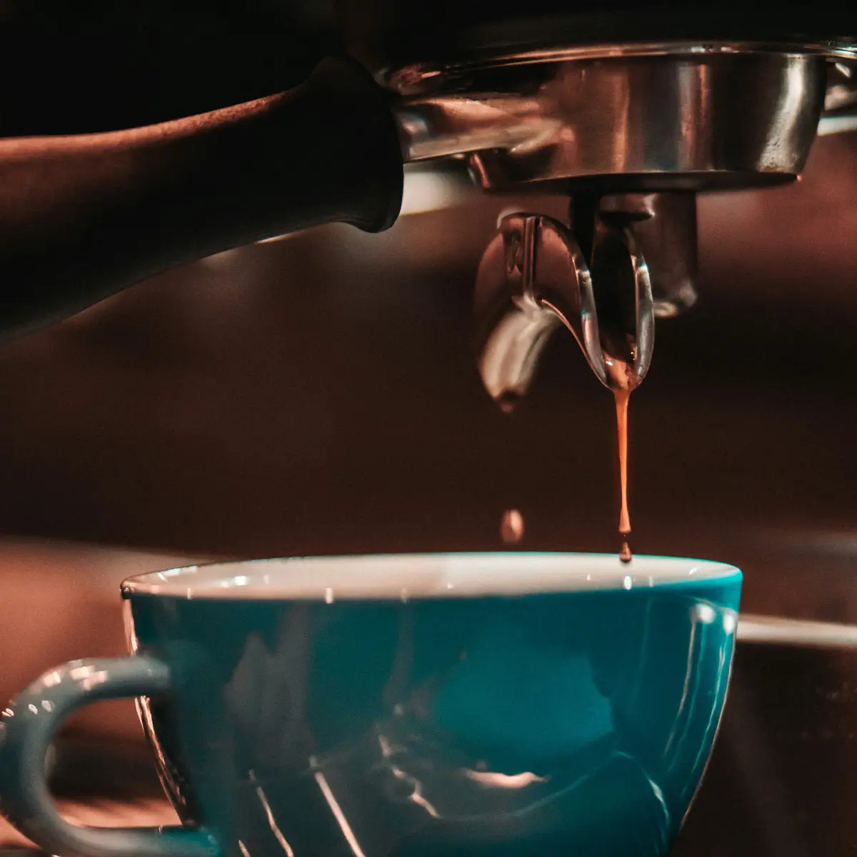 looking down at a cup of hot coffee surrounded by coffee beans