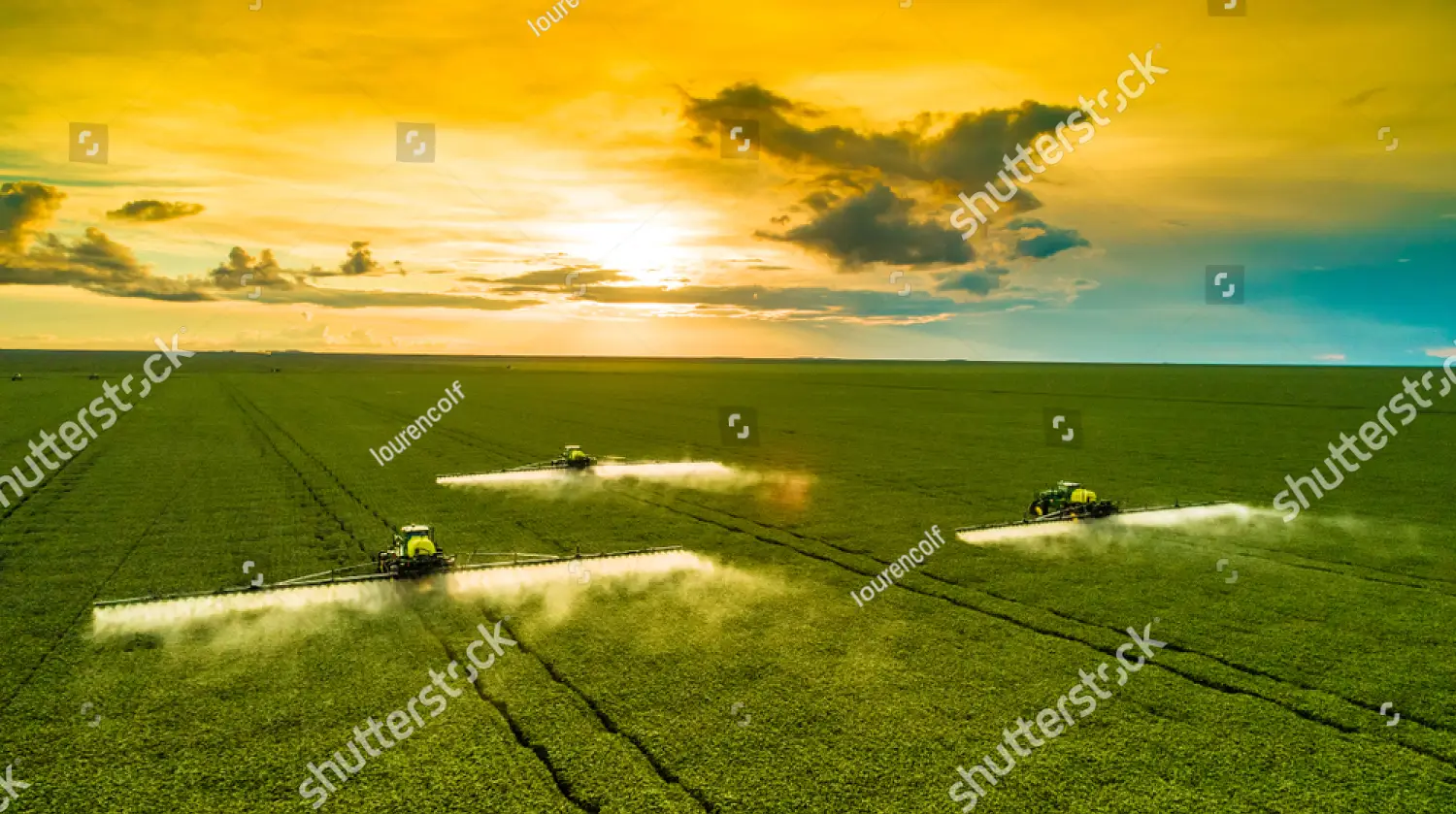 farm tractors spraying green fields