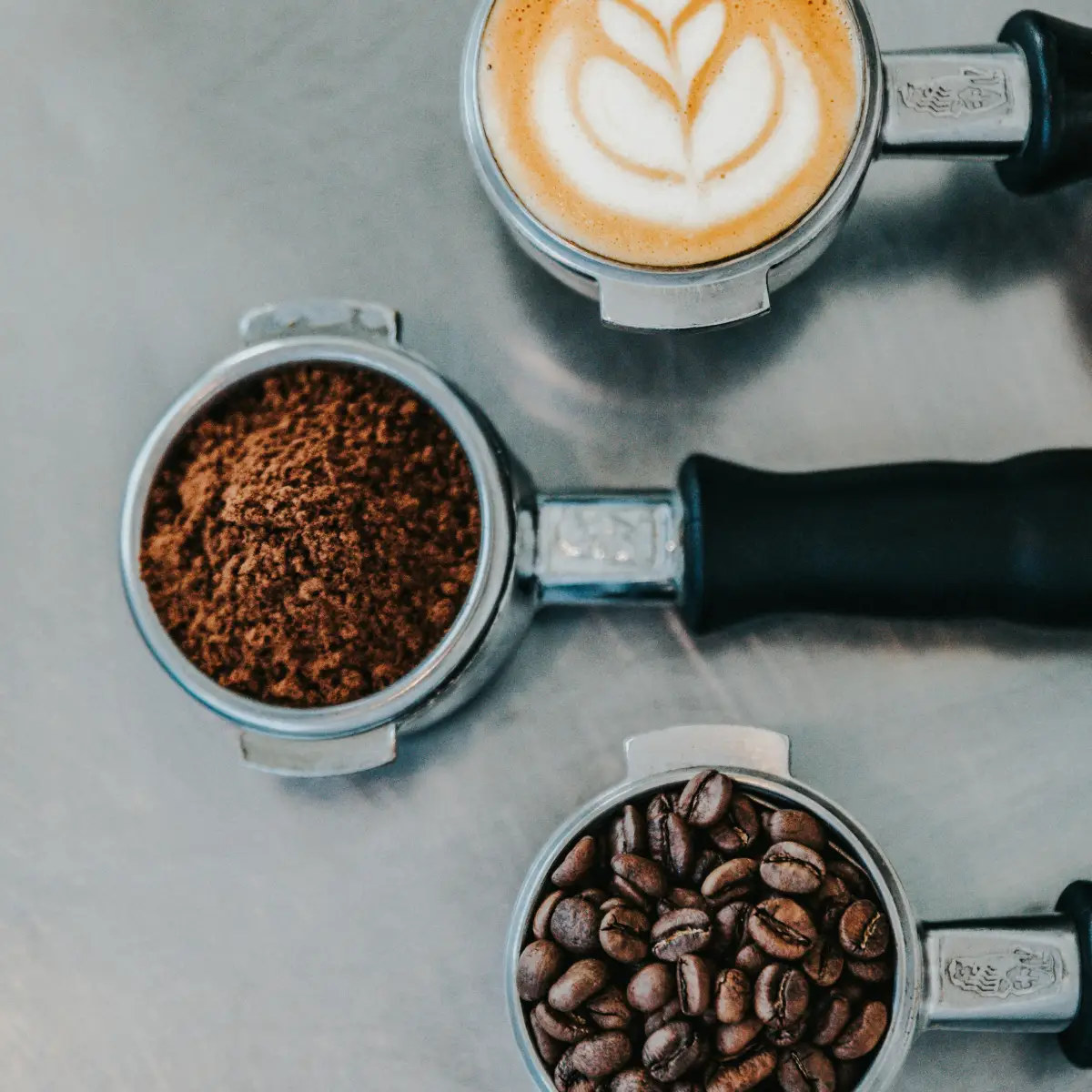 looking down at a cup of hot coffee surrounded by coffee beans