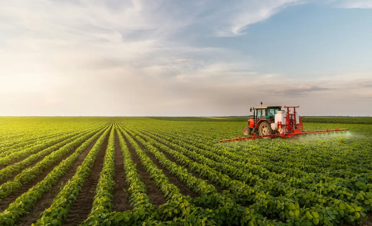 farm tractors spraying green fields